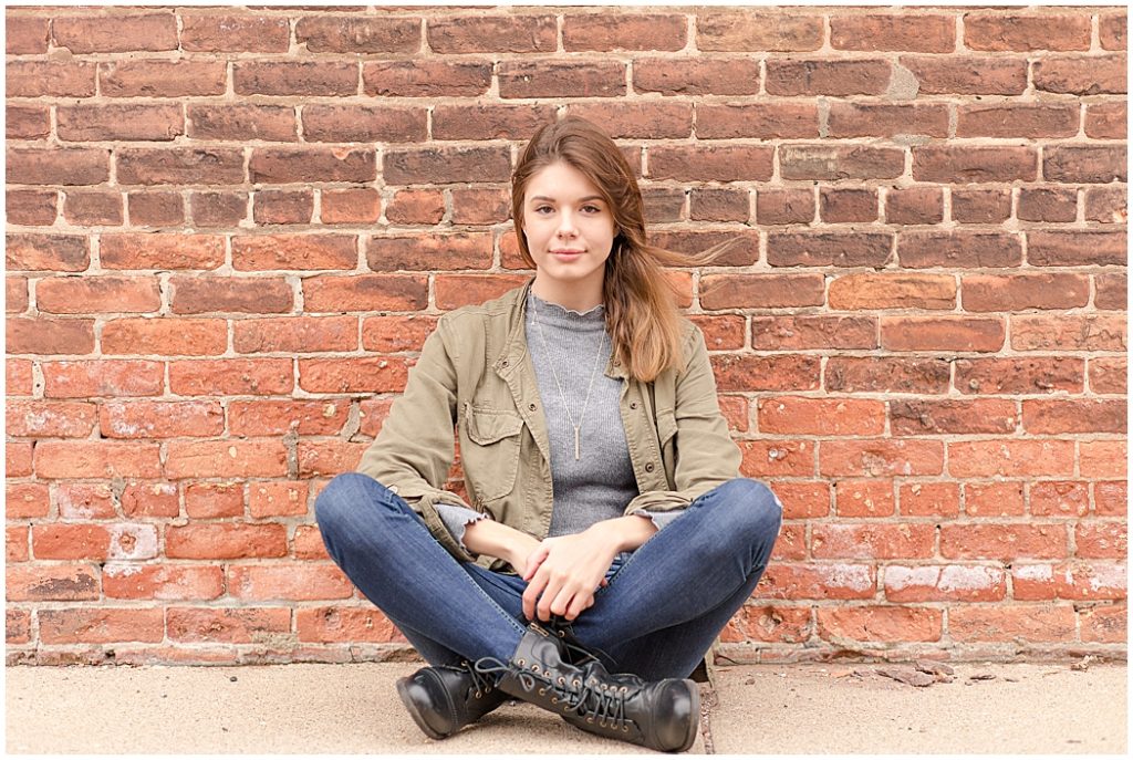 girl senior pictures in front of brick wall