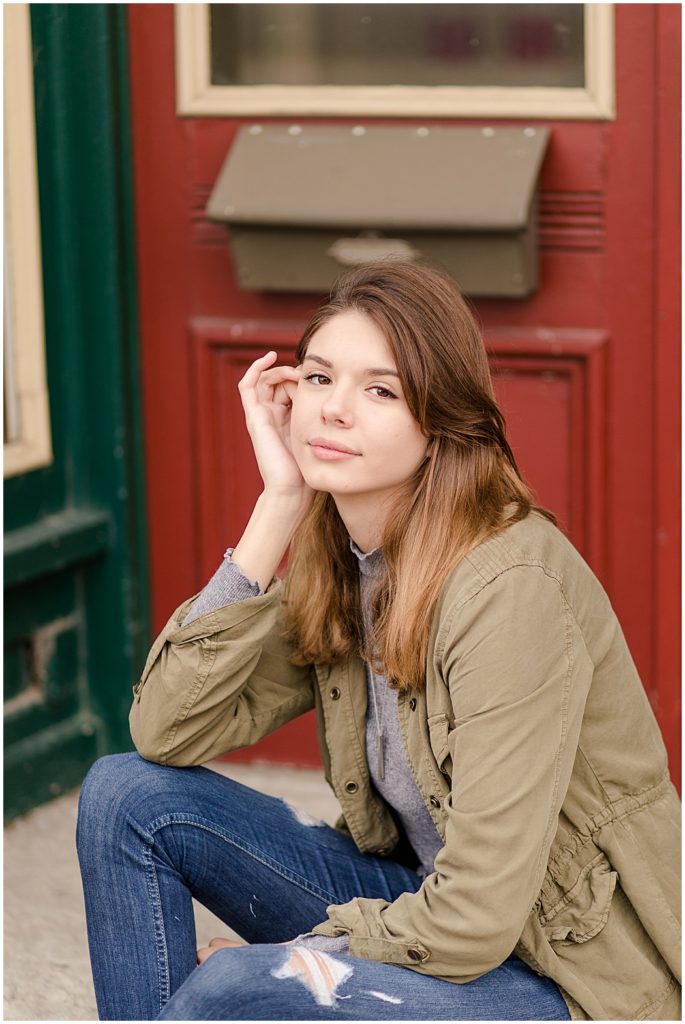 girl senior pictures in front of green building
