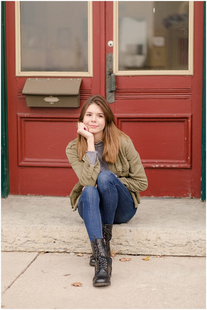 girl senior pictures in front of green building