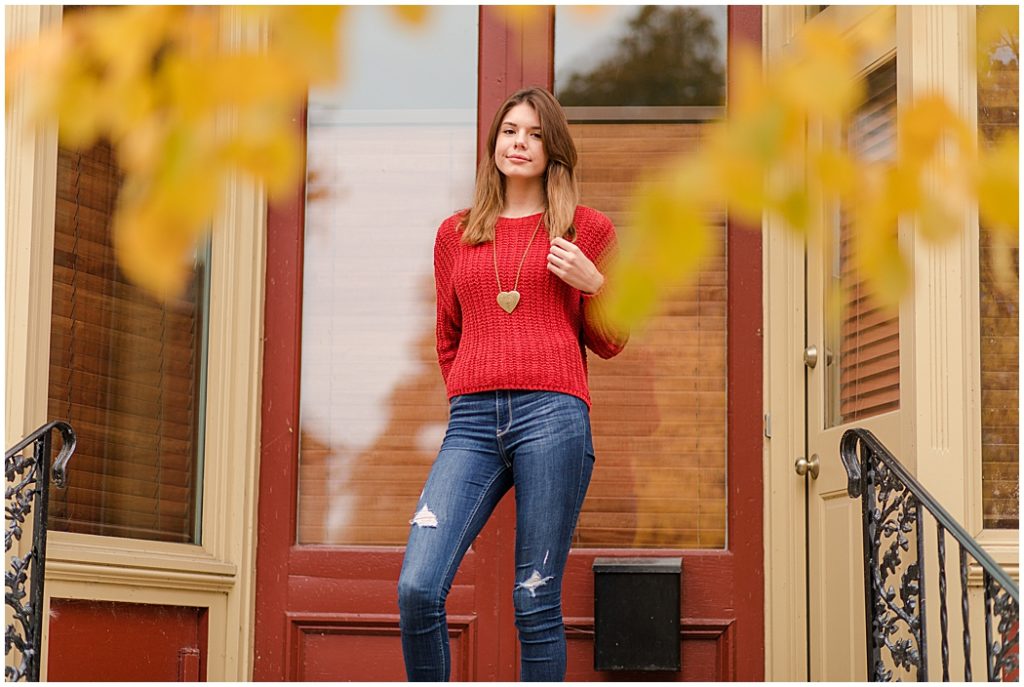 girl senior pictures in front of yellow building