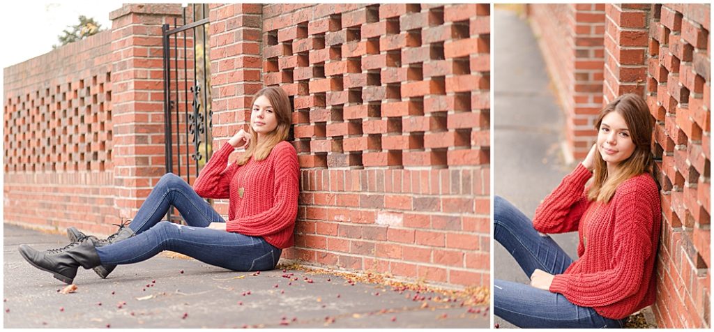 girl senior pictures sitting near brick fence