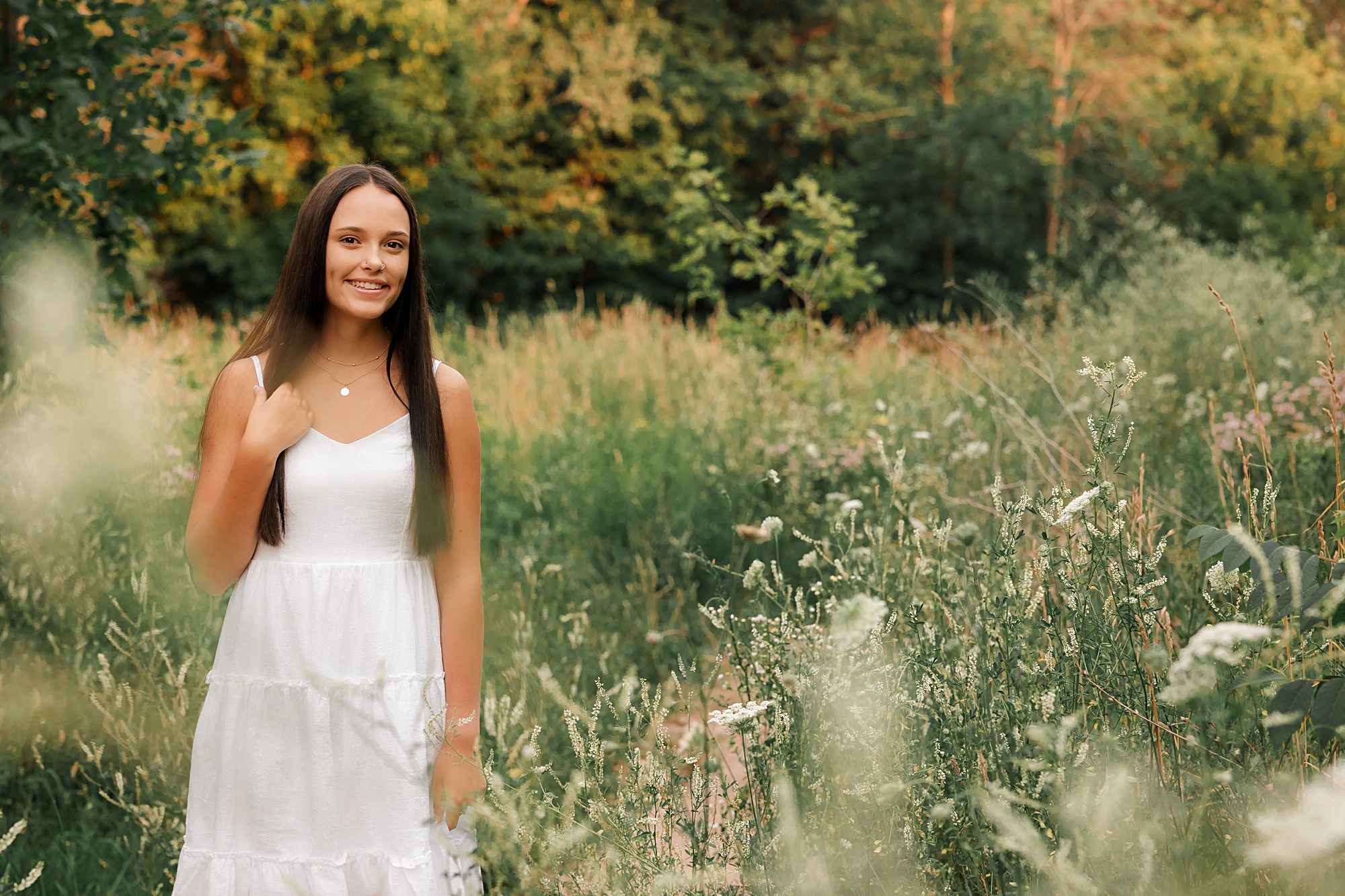 a senior photo taken in summer at Fonfereks Glen in the middle of white wild flowers.